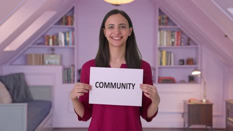 Happy-Indian-woman-holding-COMMUNITY-banner