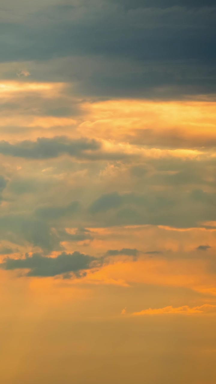 Vibrant Orange and Grey Clouds Moving Across the Sky at Sunset
