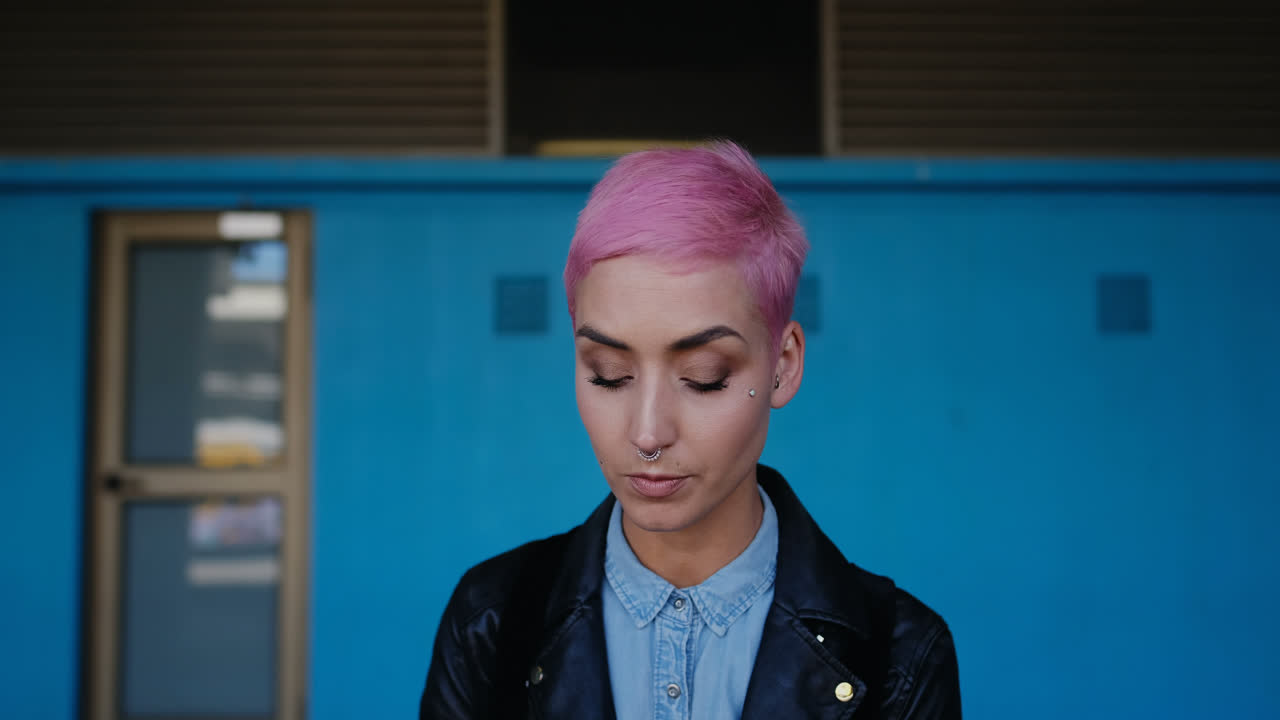 핑크 머리카락의 여성이 휴대 전화 4k로 이야기하고 있습니다.