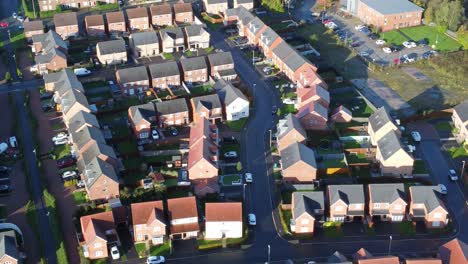 aerial view above new build modern housing estate property rooftops england pan right