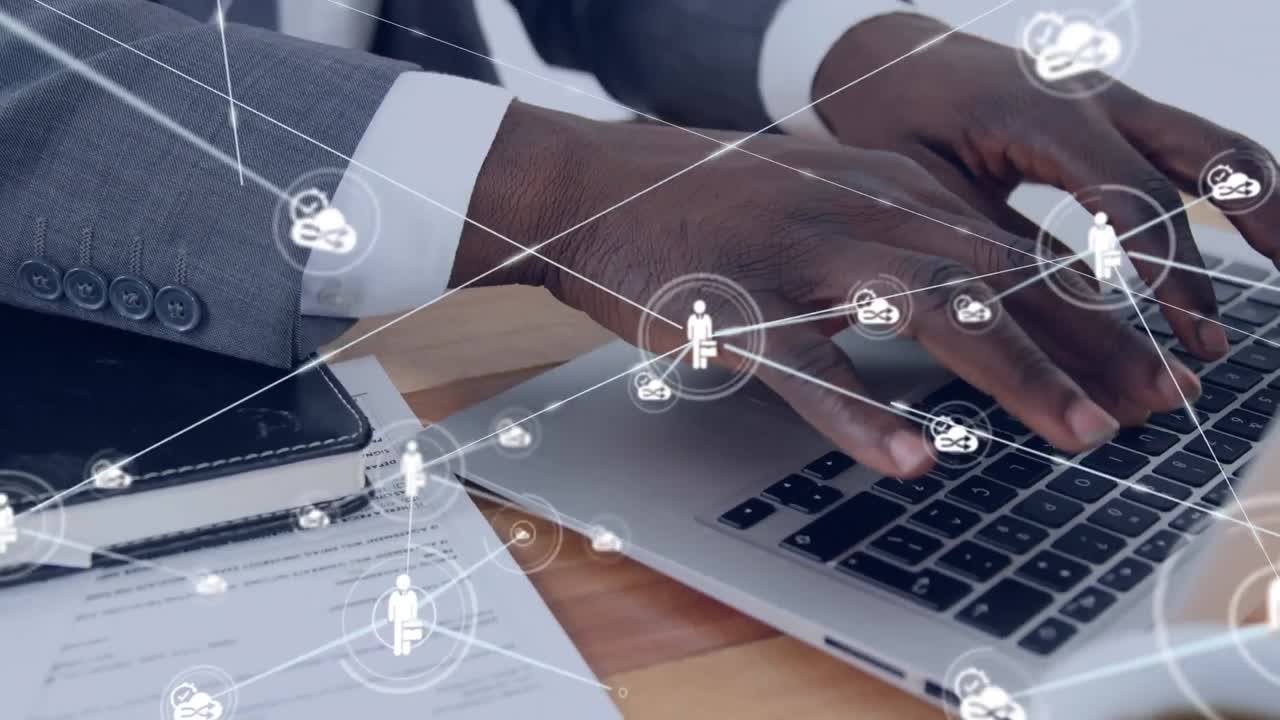 Animation of network of icons over african american businessman using laptop