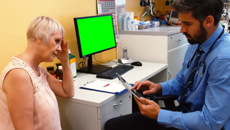 Doctor-discussing-with-patient-over-digital-tablet