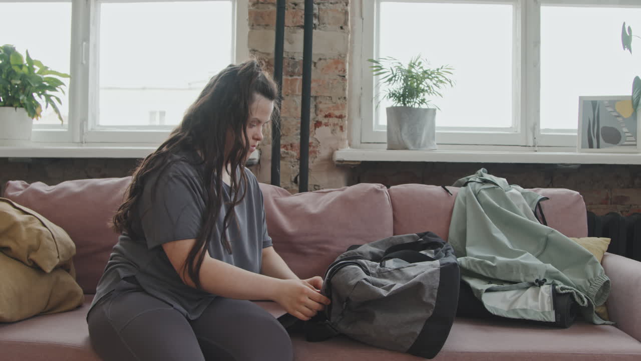 Young Woman With Down Syndrome Packing Her Things After Yoga Class