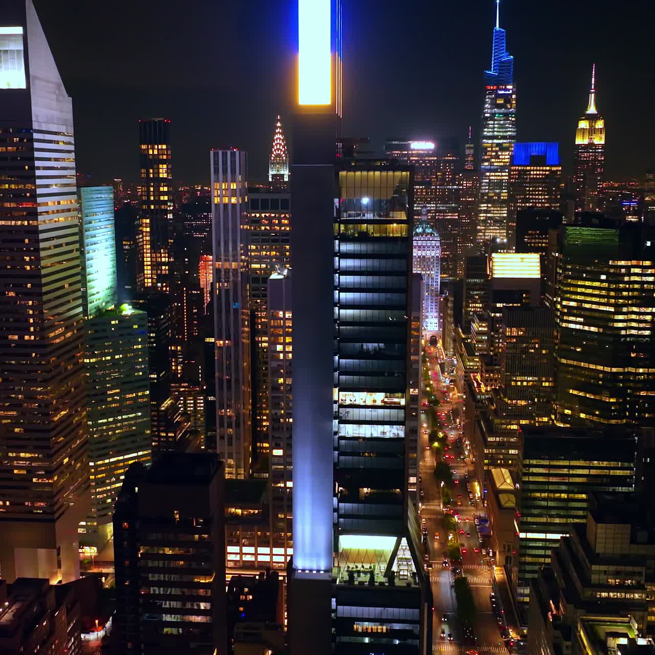 Sparkling and glamorous New York at night time. Drone flying among tremendous skyscrapers over busy streets