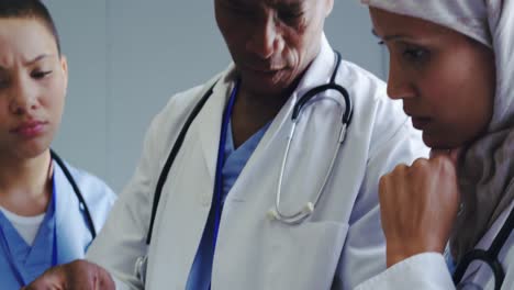 close-up of multi-ethnic doctors discussing over medical report in hospital