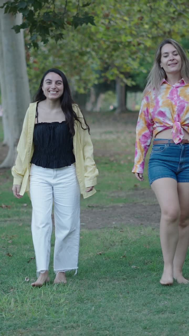 Due donne che camminano a piedi nudi in un parco