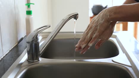 Caucasian-woman-washing-her-hands-with-soap-at-home