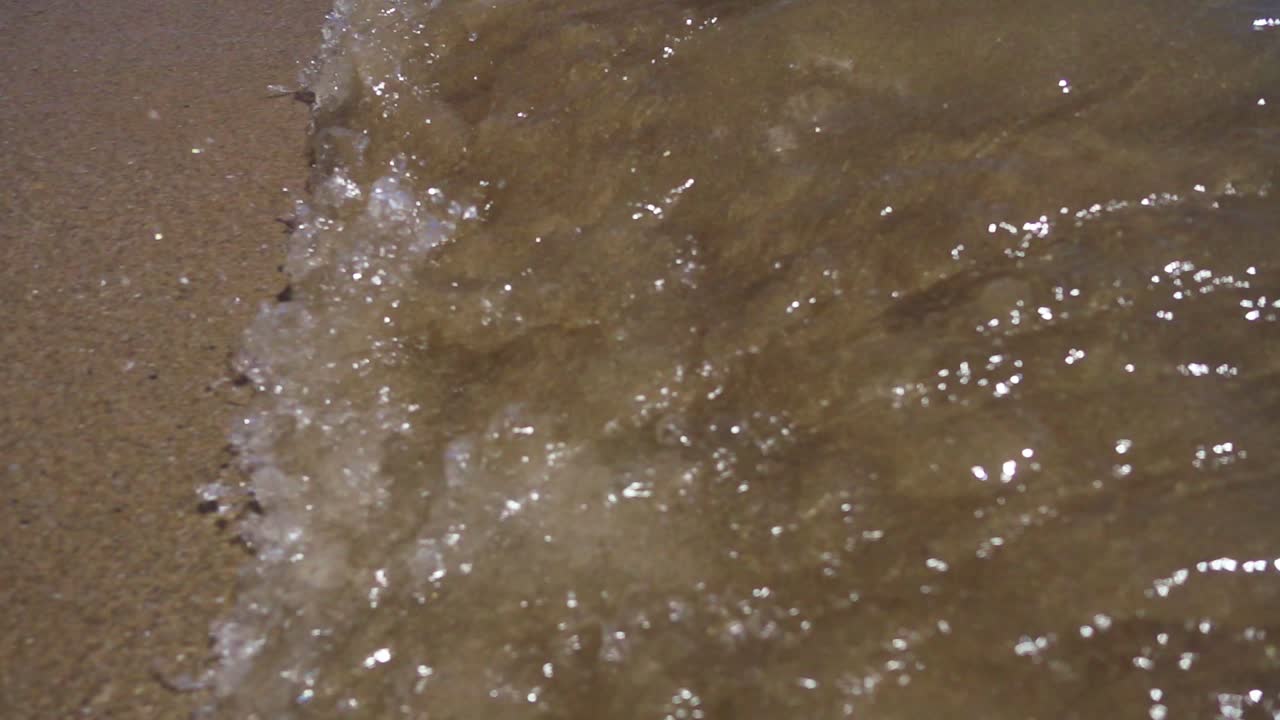 모래 해변 에 있는 바다 물결. 바다 해안 에 도달 하는 작은 물결 의 느린 움직임