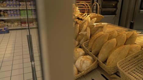 pan left shot of breads on display in supermarket bakery