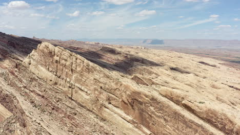 Impresionante-Clip-Panorámico-De-Drones-Sobre-El-Terreno-Rocoso-Con-Un-Desfiladero-En-El-Fondo-De-Los-Acantilados-De-Arenisca-Roja-En-El-Arrecife-De-San-Rafael-En-Utah,-EE.UU.