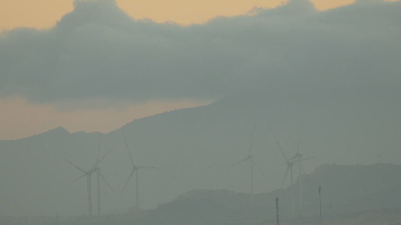 골든 아워까지 산 앞에서 굴러가는 풍력 터빈