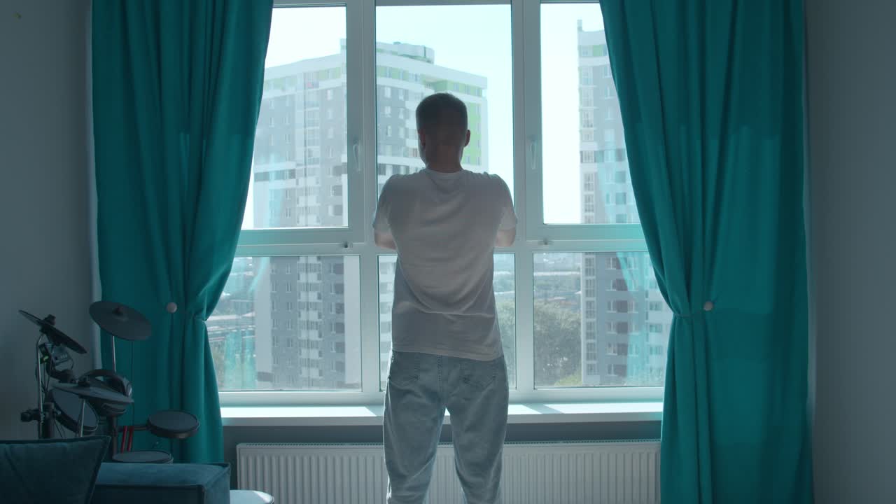 Man looking out window at cityscape