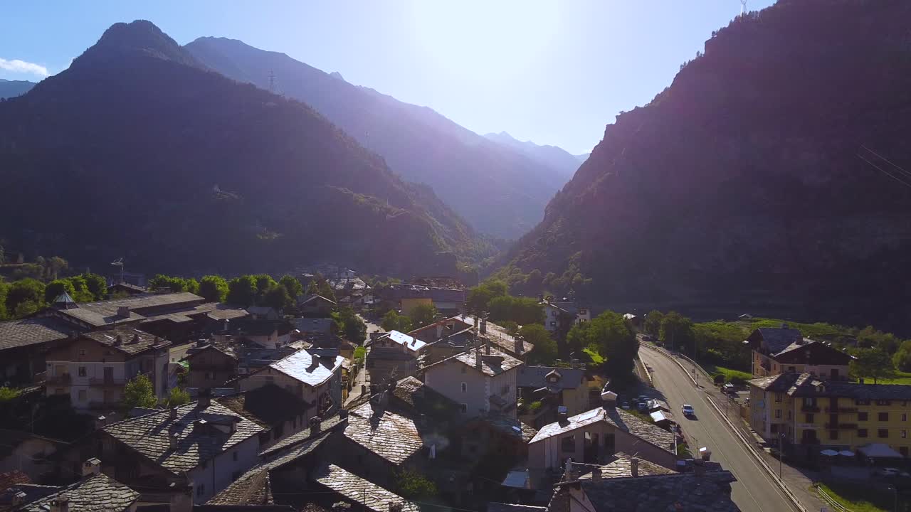 Villaggio alpino italiano in una giornata di sole, vista aerea con drone con movimento verso sinistra
