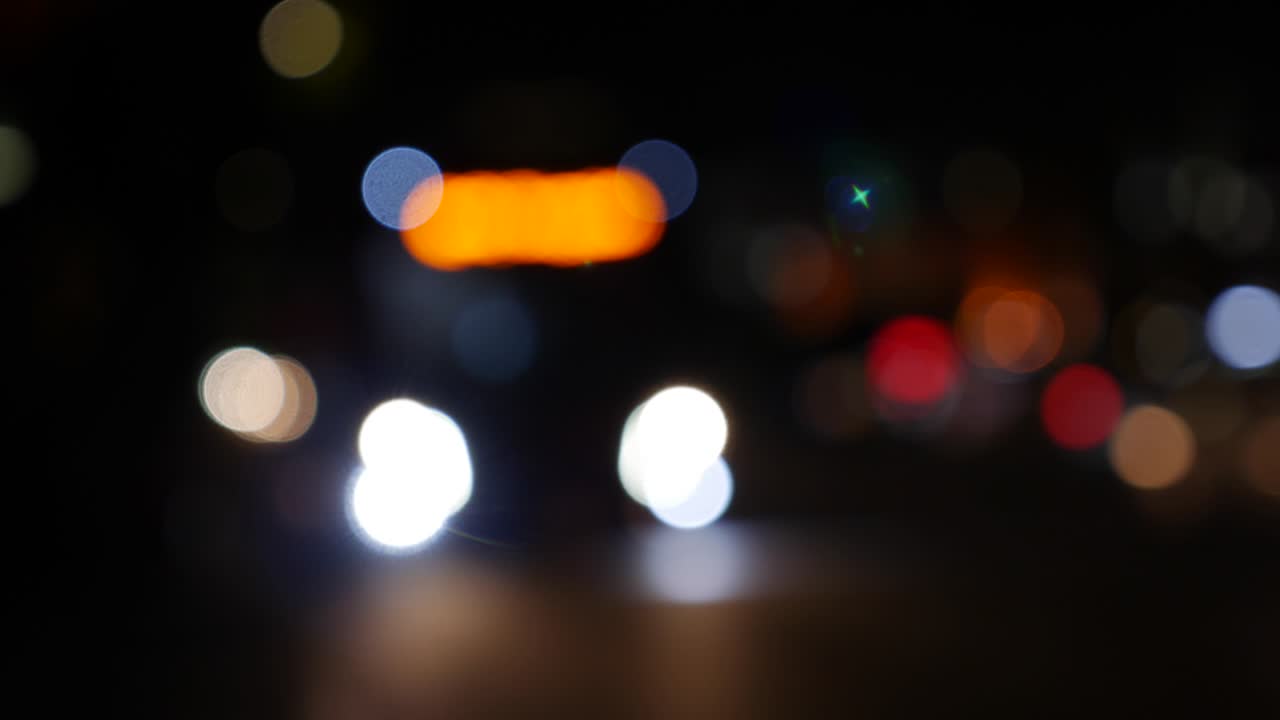hermoso bokeh brillante en el fondo oscuro borroso por la noche. el redondo bokeh colorido brilla de las luces de los coches en la calle de la ciudad. fuera de foco con borroso. luces de la ciudad sin enfoque. bokeh de tráfico. concepto abstracto