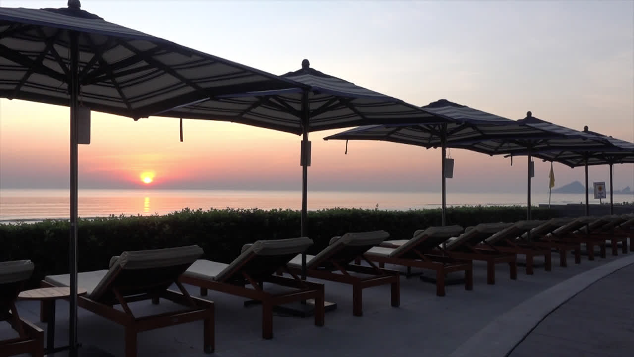 호텔 리조트의 야외 수영장 주변에 파라솔과 의자 소파