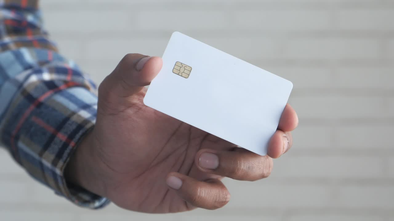 mano con una tarjeta de crédito blanca en blanco