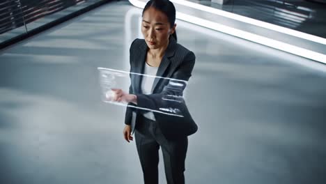 a professional woman interacting with a holographic display in a modern, high-tech environment, emphasizing innovation and digital engagement