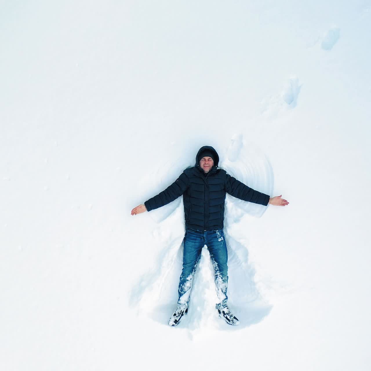 Man lying on snow in winter holiday