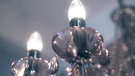 beautiful chandelier with transparent pendants and burning lamps closeup 1