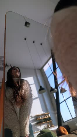 woman trying on clothes in front of a mirror