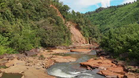 Nature-in-Laos,-river-and-orange-stones-and-land-around,-aerial-drone-view