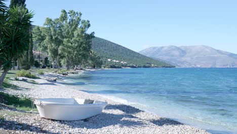 Coastal View with White Boat on Pebble Beach