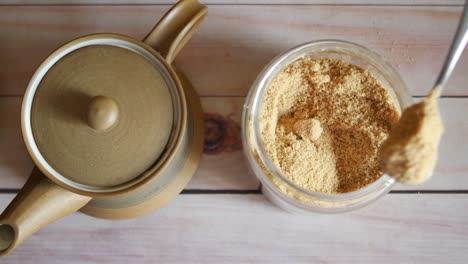 spoon pick coconut sugar from a container on table