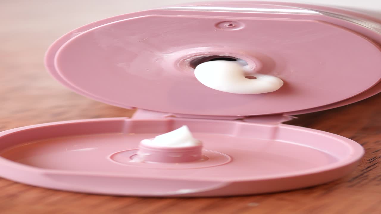 primer plano de un tubo rosa de crema hidratante