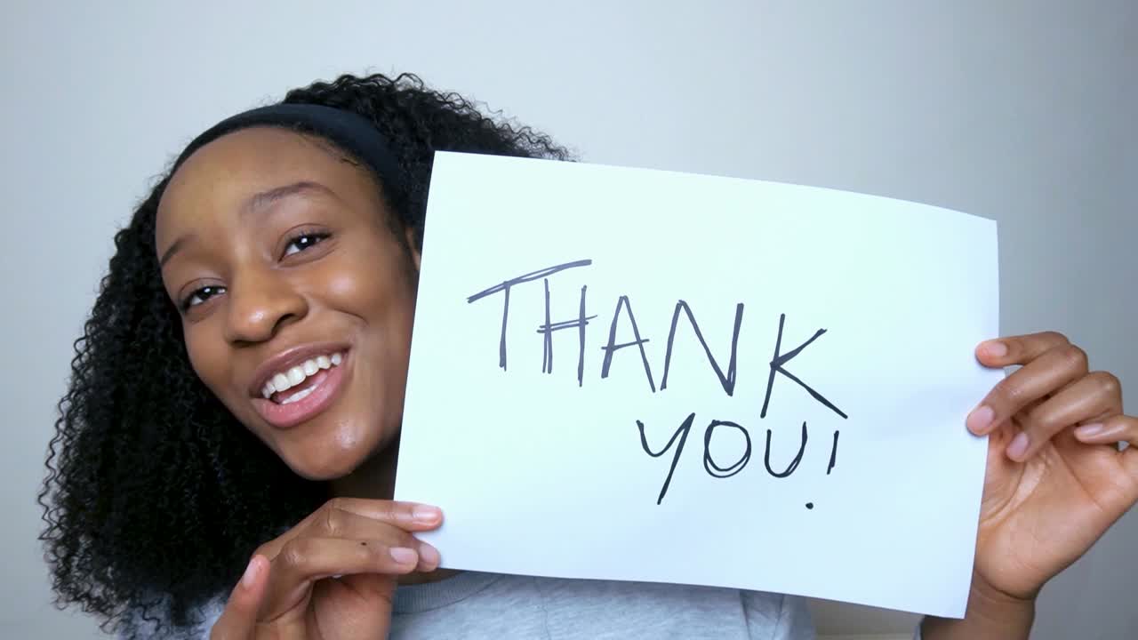 Young Student Holding Up Thank You Sign During Video Lecture