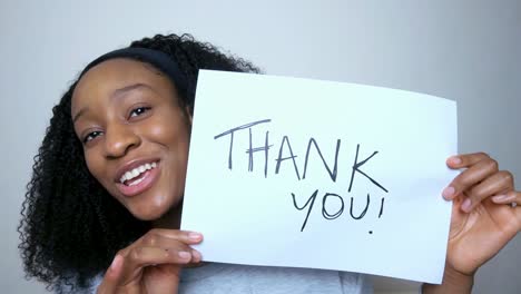 young student holding up thank you sign during video lecture