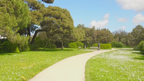 Cyclists-through-natural-alley-Pedestrian-path-in-summer-in-La-Rochelle,-France