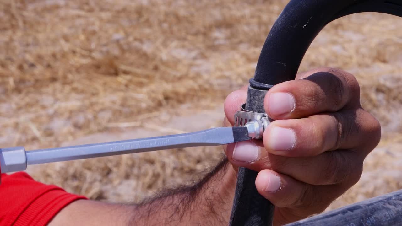 primer plano de un hombre reparando parte del sistema de riego de pivote central