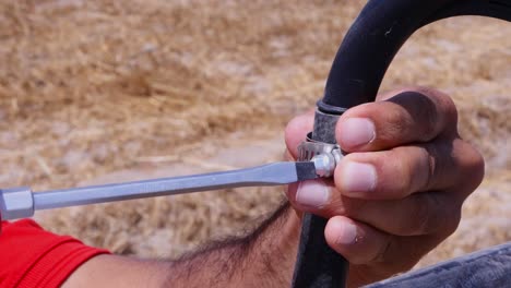 close up shot of a man repairing part of center pivot irrigation system