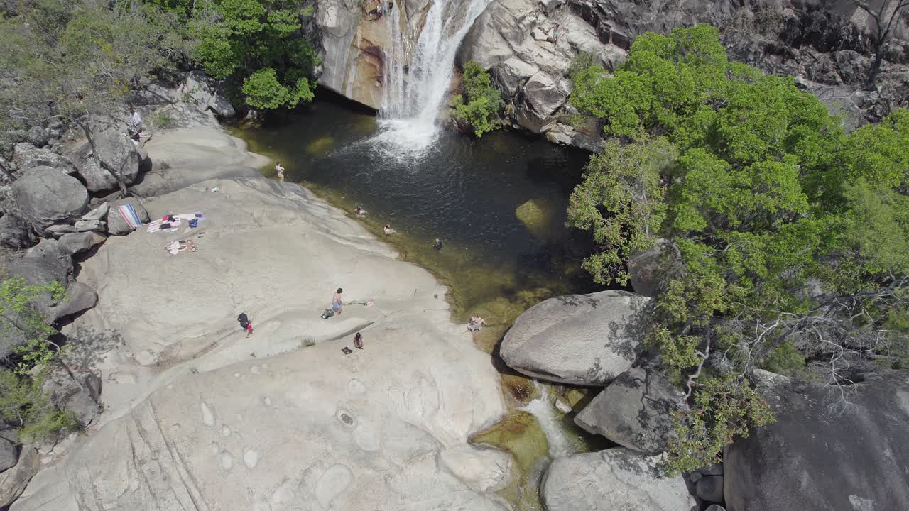 turistas nadando en la cuenca de la piscina natural en las cataratas de emerald creek