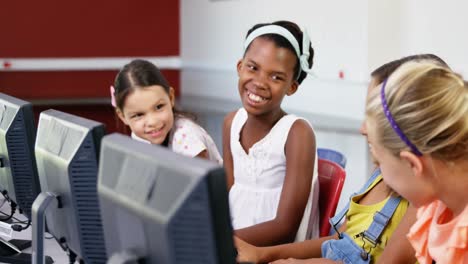 schoolgirls using computer in classroom