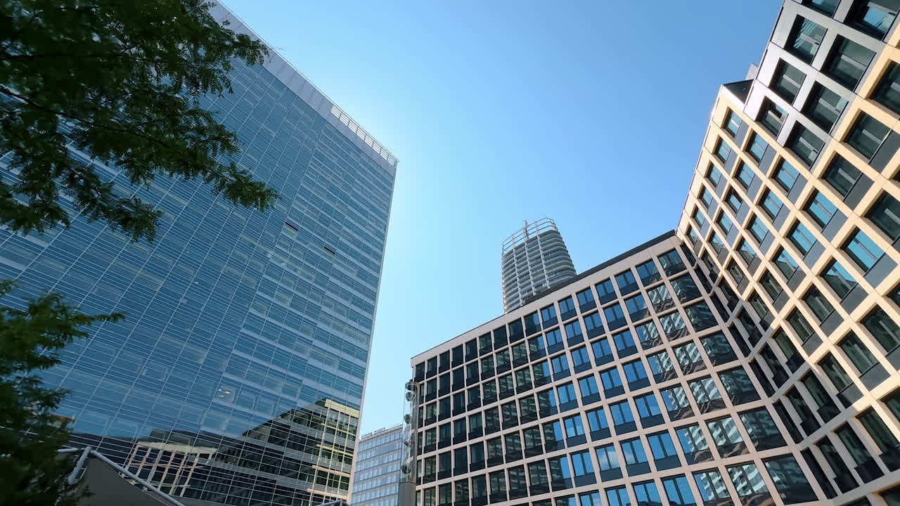 Exteriors of the modern buildings in the town or city. Low angle view at the architecture design at the backdrop of blue sky