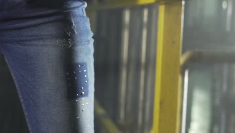 closeup of a workers hands warping denim thread