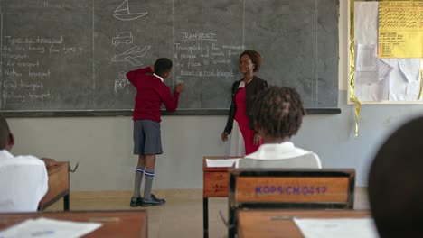 african student writes on the blackboard in uganda