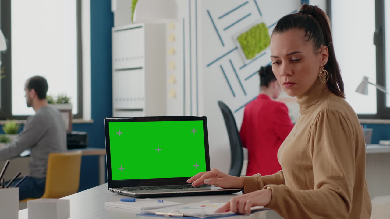 Business woman using laptop with green screen