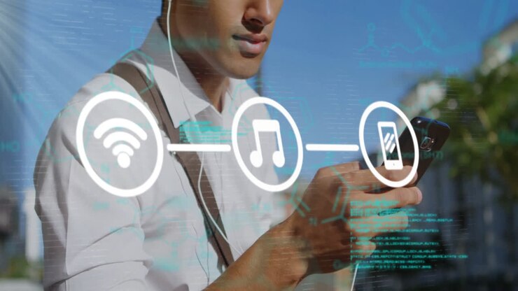 Holding smartphone, man with headphones and network connectivity animation overlaid
