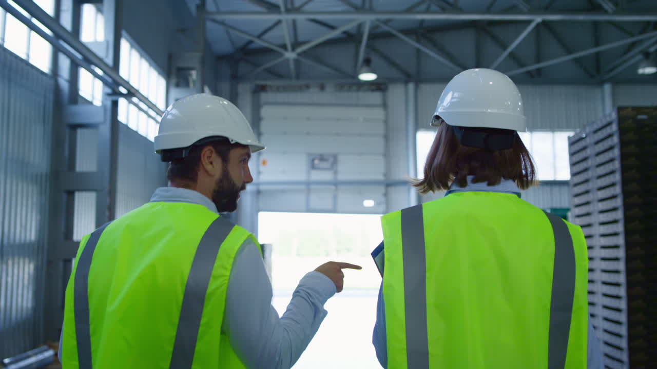 trabajadores de la fábrica mirando hacia atrás caminando en el almacén discutiendo la gestión del almacenamiento
