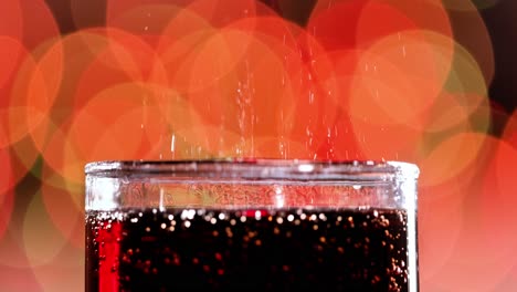 glass of cola. ice cola with splashing bubbles slow motion on a blurry light ,blurry background.