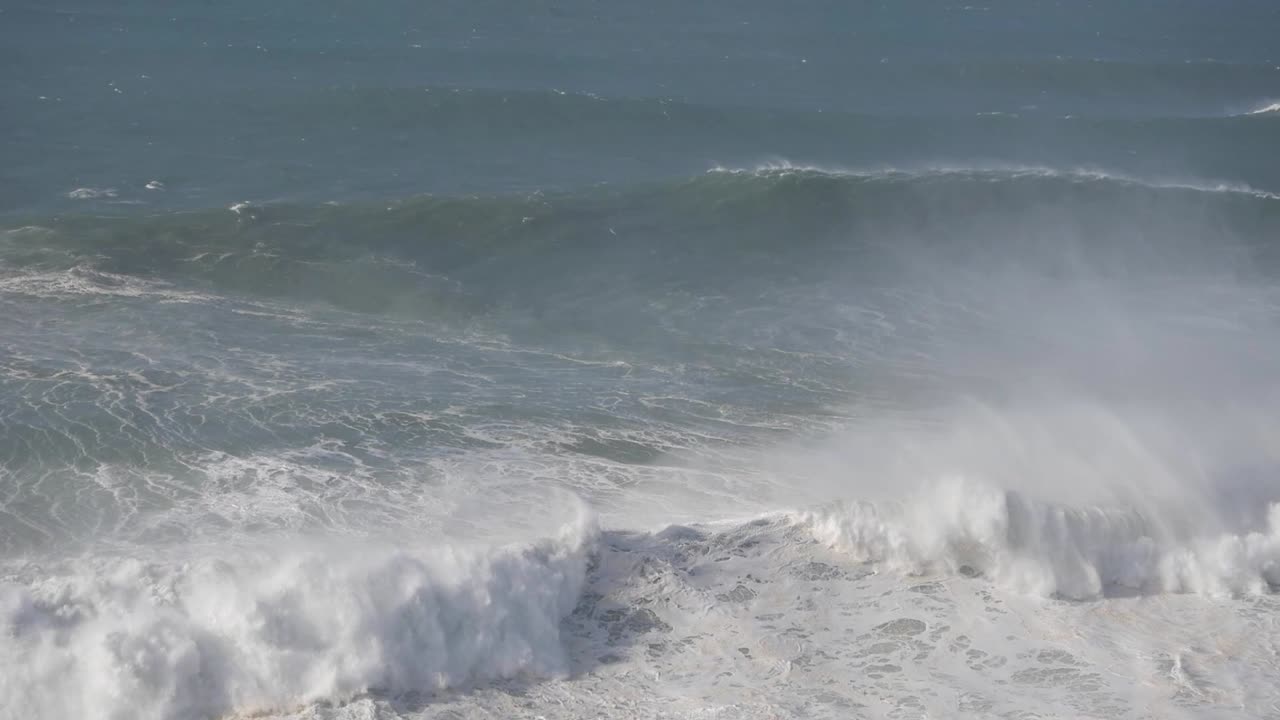Enormous waves crashing in Nazare, Portugal, showcasing the power of the ocean
