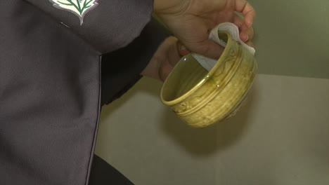 tea bowl is ritualistically wiped dry during a japanese tea ceremony