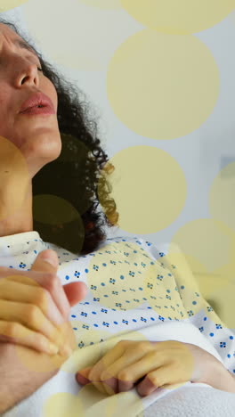 animation of yellow spots over caucasian man and biracial pregnant woman in labour