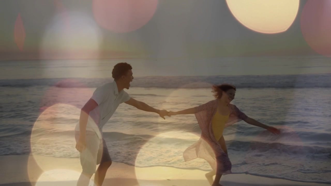 Coppia che si tiene per mano al tramonto, l'uomo che tira e fa volteggiare la donna, un inseguimento giocoso, con un bokeh che evoca il viaggio.