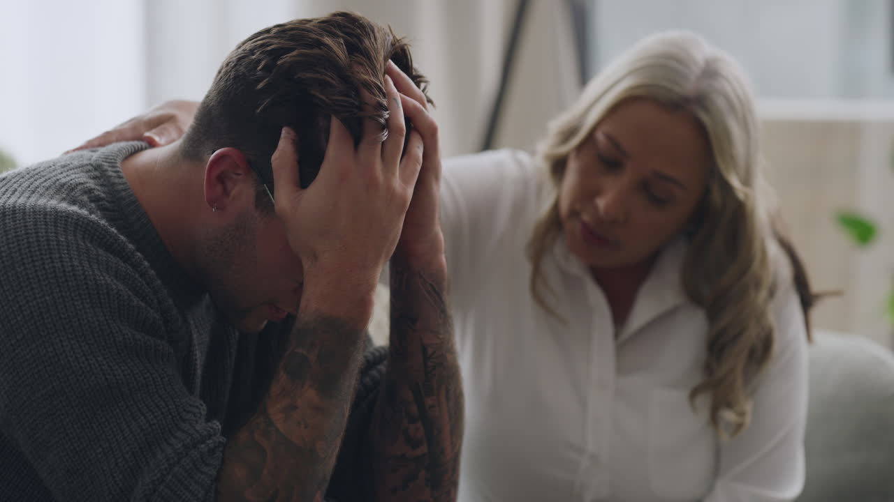 hombre llorando y siendo consolado por un psicólogo