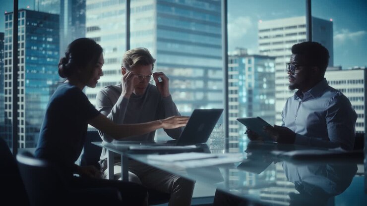 Multiethnic Diverse Office Conference Room Meeting: Team of Three Creative Entrepreneurs Talk, Discuss Growth Strategy. Stylish Young Businesspeople Work on Digital e-Commerce Startup Project.