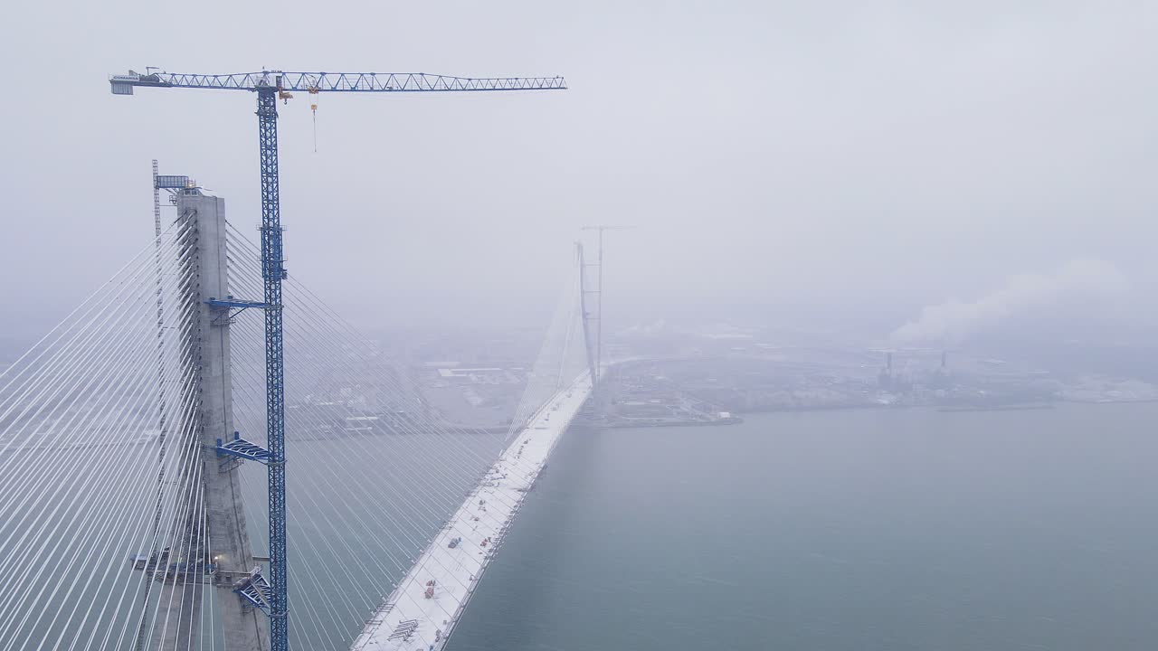 Gordie Howe Bridge emerges through dense fog during early construction in Detroit, USA