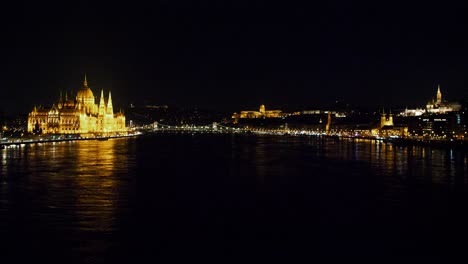 Budapest-city-and-Danube-river-at-night,-gothic-architecture,-light-reflections,-wide-panoramic-shot